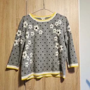 (S) Grå blommig tröja från Cooperative - Jättecharmig grå prickig retro/vintage tröja från Cooperative med blommigt mönster. Tröjan har trekvartsärmar och gula detaljer vid hals och ärmslut. 70-tal och "bookgirlie"-vibes. 