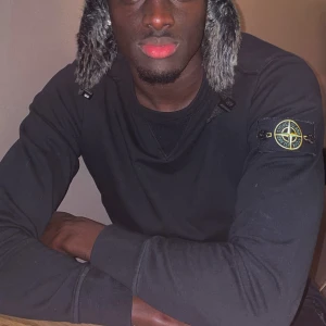 Svart tröja från Stone Island - Säljer en stilren svart tröja från Stone Island med deras ikoniska märke på ärmen. Tröjan har en rund hals och långa ärmar, perfekt för en casual look.