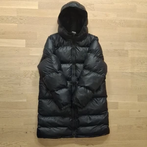 Lång Nike jacka - Säljer en riktigt snygg nike jacka i storleken XS. Den är i jättebra skick, den är målad på storleken, annars är allt som det ska. Den är väldigt varm och perfekt för vintern. Priset kan diskuteras