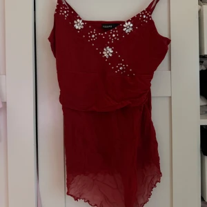 Lång fest topp  - Snygg röd fest topp från Rock'n Blue med pärldetaljer på axelbanden och överdelen. Står att den är M men skulle säga att den är lite mer en S.