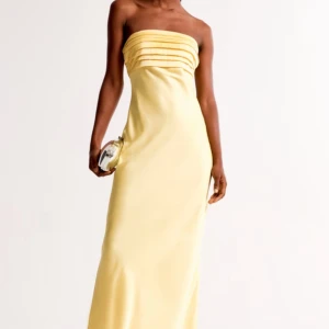 Balklänning  - Säljer denna superfina gula balklänning från Abercrombie & fitch. Storlek xxs, helt ny prislapp sitter kvar. Medföljande band finns ifall man ej vill ha den axelbandslös. Lägger ut igen pga oseriös köpare.