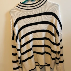 Randig tröja från ONLY - Säljer en snygg randig tröja från ONLY i svart och vit. Tröjan har långa ärmar och en ribbad struktur som ger en skön passform. Perfekt för en stilren look.