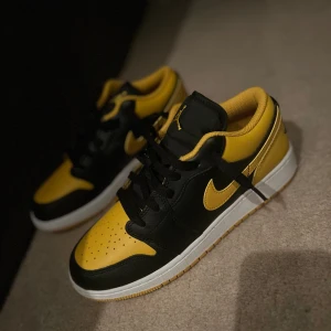 Nike sneakers i svart och gul - Snygga Nike sneakers i svart och gul med klassisk snörning. Perfekta för en sportig look med en iögonfallande färgkombination. Skorna har en vit sula som ger en fräsch kontrast. Skorna är 100% äkta dom är också helt nya jag säljer dom för köpte fel storlek och har inte kvitto 