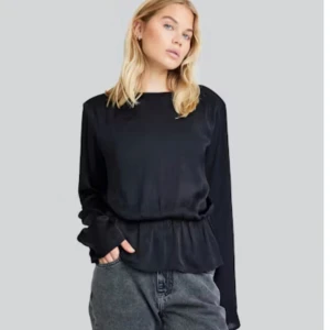 Svart blus med volangdetalj - Säljer denna svarta blusen från Bikbok med volangdetalj vid midjan, strl XS, endast använd några gånger, fint skick, 100kr+frakt🩵