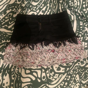 Volangkjol - Trendig kortkjol i svart med blommigt mönster och spetsdetaljer i volang💕.  Dm vid frågor