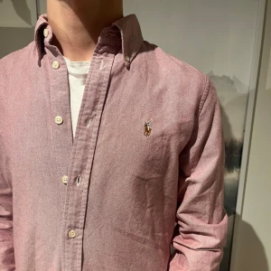 Ralph Lauren skjorta - Vi Säljer nu denna väldigt snygg rosa skjorta från Ralph Lauren i bomull |väldigt fint skick inga defekter | Storlek M men sitter som S | ny pris 1799kr men säljs nu för endast 399kr!