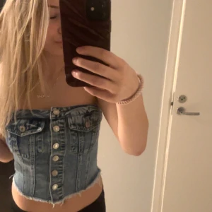 Jeans korsett - Snygg jeans korsett med knappar framtill och fransig nederkant. .