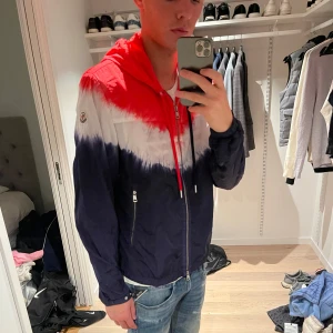 Moncler Vindjacka  - Snygg vindjacka från moncler, i röd, vitt & mörkblå storlek 3 Passar L/M jag är 187 och väger 65kg.