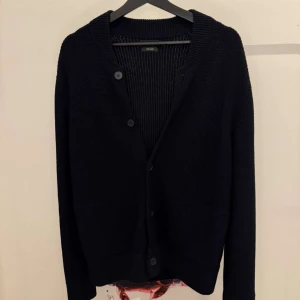 Svart cardigan/kofta - Elegant svart kofta från Massimo Dutti med knappar framtill. Perfekt för en stilren look och passar bra till både vardag och mer uppklädda tillfällen. Knappt använd.