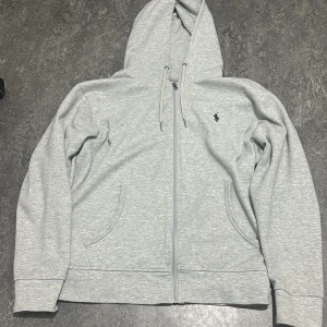 Ralph Laurent zip - Jag säljer en grå Ralph Laurent zip. Den är helt ny inte använd och fakturan finns. Som ni ser nypris är 2099kr men jag säljer den för 900kr. Den passar för allt om du ska ut med vänner eller ut med familjen. Anledningen att jag ska sälja den är för att jag bad min pappa att köpa den till och jag visste inte vilken storlek jag ska ta så när jag fick så märkte jag att den var för liten. Priset kan diskuteras! Så passa på och skriv till mig 