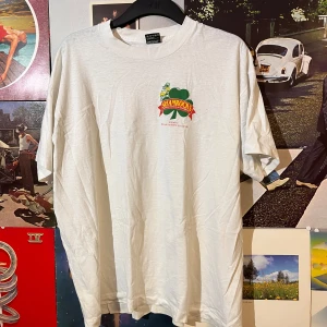 Vit vintage t-shirt från Fruit of the Loom - Säljer en vit t-shirt från Fruit of the Loom med ett tryck av en grön shamrock och texten 'Shamrocks Against Muscular Dystrophy'. T-shirten är i storlek XL och tillverkad av bomull och polyester. Dm vid frågor