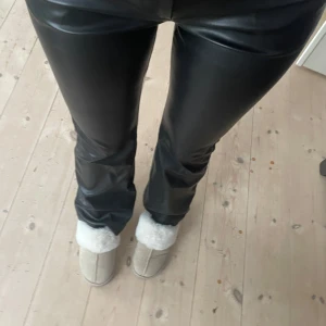Svarta skinnbyxor - Snygga svarta skinnbyxor i tight passform. Perfekta för en cool och stilren look. De är högmidjade och passar bra till både vardag och fest. Byxorna har en glansig finish som ger en extra touch av elegans.