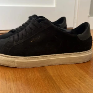  Axel arigato  - Säljer ett par svarta sneakers från Axel arigato  i bra skick. De har en stilren design med snörning och en vit sula som ger en snygg kontrast. Perfekta för vardagsbruk och passar till det mesta i garderoben. Sköna och enkla att matcha! Priset går att diskutera kan skicka mer bilder det går att rengöra dom