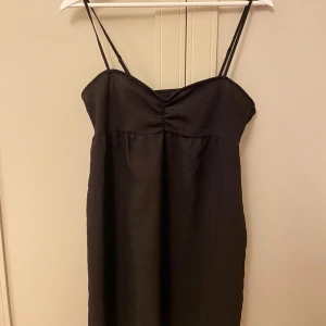 Svart klänning - Snygg svart klänning med smala axelband, perfekt för fest eller en utekväll. Den har en enkel design som gör den lätt att matcha med olika accessoarer. 💕💕 knappt använd, storlek 38💞