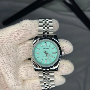 39mm Seiko Datejust Tiffany Dial Mod - Tja. En sjukt snygg Tiffany Dial på denna Datejust. Öppen baksida, NH38 automatisk Seiko rörelse samt 904L rostfritt stål. As häftig klocka som är gedigen och lagom tung. Passar vem som helst. Kan va lite mer rörlig med priset nu inför jul ;)