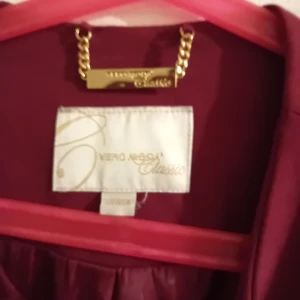 Vinröd kappa från Vero Moda - Säljer en elegant vinröd kappa från Vero Moda Classic. Perfekt för höst och vår med sin stilrena design. Den har en klassisk passform och är i mycket bra skick. Perfekt för att ge din outfit en touch av färg och stil!