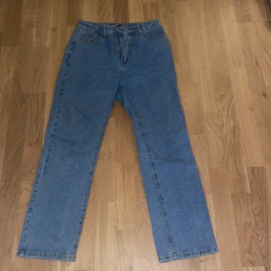 Blå jeans  - Säljer ett par klassiska blå jeans i mycket bra skick. De har en rak passform och hög midja, perfekt för både vardag och fest. Jeansen har en dragkedja och knapp framtill. Fickor både fram och bak för praktisk användning. Passar perfekt till alla säsonger!