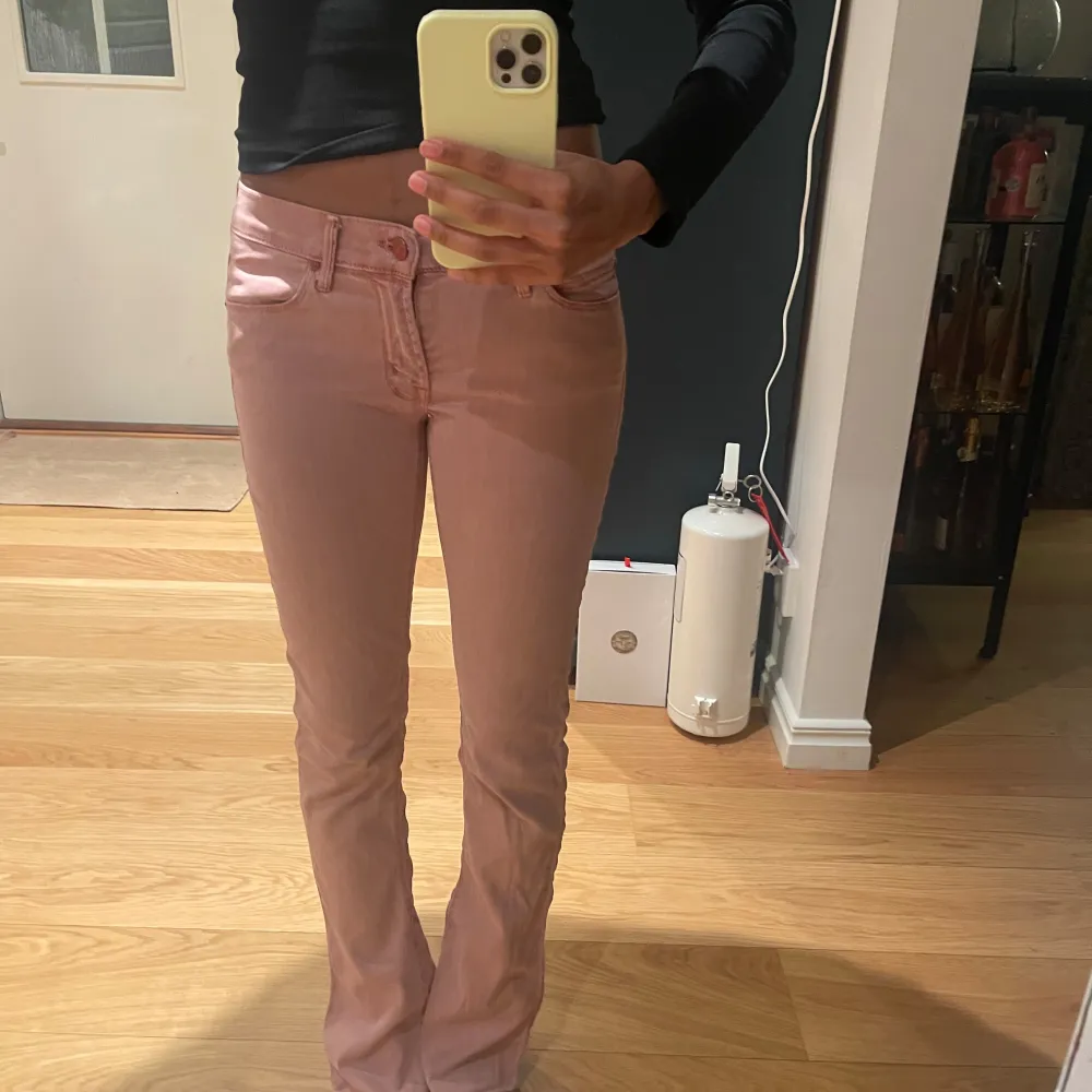 Snygga rosa bootcut byxor. Perfekta för en trendig look. Byxorna har en klassisk design med knappar och dragkedja framtill.. Farkut & Housut.