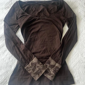 långärmad brun tröja - jätte gullig och mysig brun långärmad tröja med snygga detaljer på handleden 💞 säljer pga inte kommer t användning!