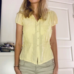 Söt gul kortärmad blus/skjorta - Oroligt söt unik klassisk ljusgul kortärmad blus/skjorta. Från pepe jeans, köpt för länge sedan och jätte fint skick. Den har små justerbara band i sidan så man kan välja form. Storlek x/xs