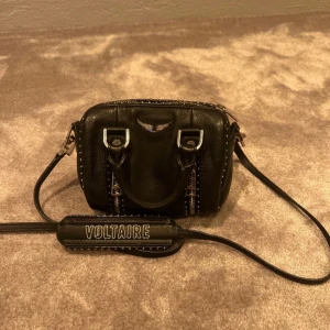 Zadig & Voltaire väska - Snygg äkta väska från Zadig & Voltaire i modellen Sunny bag, enda ”defekten” är knopparna på toppen av väskan(se sista bilden) annars är den som helt ny. Rymmer mer än vad man tror och är enligt mig en perfekt liten skolväska💞 Dustbag medföljer!