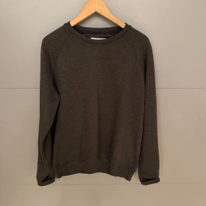 Mörkgrå tröja från Pier One - Säljer en stilren och bekväm mörkgrå tröja från Pier One. Perfekt för både vardag och avslappnade tillfällen. Tröjan har långa ärmar och en klassisk rund halsringning. Den är i bra skick och passar perfekt till höst- och vintergarderoben.