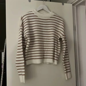 Stickad tröja - Rosa/vitrandig stick tröja. Från NA-KD. Stl 34.