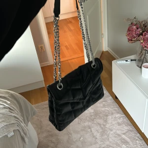 Svart väska  - Quiltad svart väska med silvriga detaljer, många fack till förvaring💕 silvrig kedja som band som går att göra båda långt och kort 