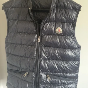 Moncler Gui Väst - Moncler Gui Väst  -Storlek: 3  -Skick 9/10  -Nypris: 8999kr -Vårat pris: 3200kr -Frakt: (hemlevererat spårbart)📦  Tveka inte att höra av dig vid minsta frågan!