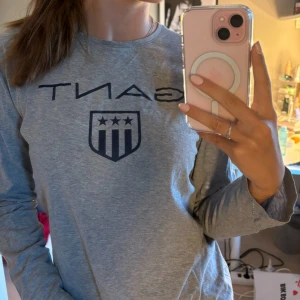 Grå långärmad tröja från GANT - Säljer en stilren grå långärmad tröja från GANT. Den har en klassisk rund halsringning och ett snyggt tryck med GANT-loggan på framsidan. Perfekt för en avslappnad men ändå stilfull look. Tröjan är i bra skick och passar perfekt till både vardag och lite mer uppklädda tillfällen. Passar mig (xs-s)🌟