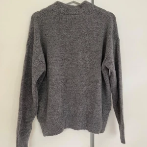 Grå stickad tröja - En fin stickad tröja från bikbok i storleken small. Tröjan är knappt använd, så är i i princip i nyskick🌸  Sitter lite lätt oversized🤗
