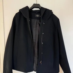 Kort kappa - Jag säljer en super fin och enkel svart kort kappa från only som inte längre går att köpa, den är varm och kommit till användning men är i bra skick🌟  Skriv för fler bilder om du är intresserad!