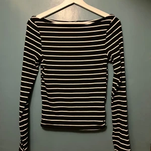 Randig långärmad tröja från Gina Tricot - Säljer en superfin svart och vit randig långärmad tröja från Gina Tricot. Perfekt för både vardag och lite mer uppklädda tillfällen. Tröjan är i storlek M och har en klassisk passform som är både bekväm och stilren. Ett måste i garderoben för alla som älskar tidlösa mönster!