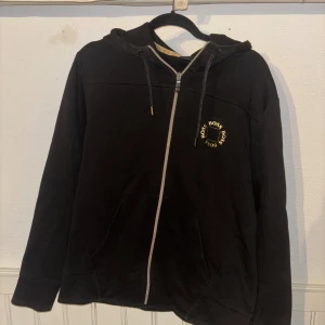Hugo Boss zip hoodie  - Hugo boss hoodie med guldiga detaljer, har lite knotter men annars bra skick, inga hål eller andra skador, knotter går att få bort Storlek L men passar även M