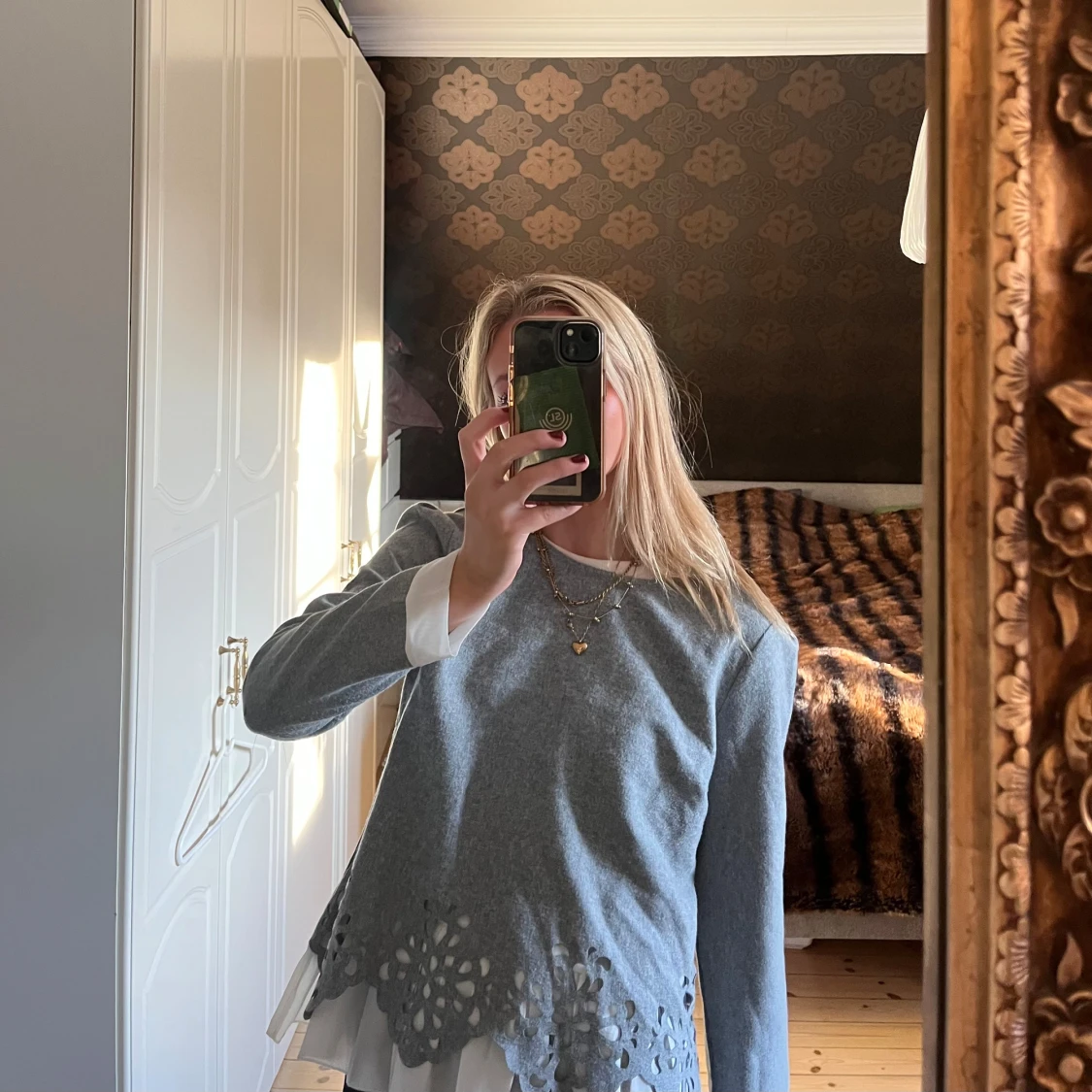 Grå tröja med spetsdetaljer och vit blus under