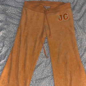Orange mjukisbyxor från Juicy Couture - Snygga vintage byxor från Juicy Couture med broderad JC-logga på sidan. Byxorna har en bekväm resårmidja med snörning.  Älskar dom men tycker dom är lite för korta, använt en gång, men de är för korta för mig som är 169. LÄGG PRISFÖRSLAG!!kan sänka vid snabbaffär 