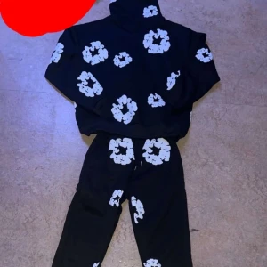 Denim tears  - Hej säljer Denim tears tracksuit Cool svart hoodie med vita blommor över hela. Perfekt för en avslappnad stil Skick 10/10 aldrig använd. Den är bekväm och passar bra för vinter och höst 