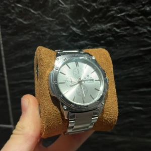 Silverfärgad klocka från Maxel - Stilren silverfärgad klocka från Maxel med metallarmband och kronografdetaljer. Perfekt för en elegant look. Kan göra så att en outfit sticker ut mer och får mer karaktär. Skriv för mer info.