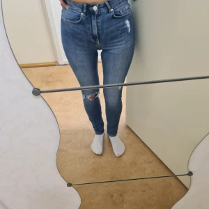 Blå skinny jeans med ett hål H&M 34 - Har tyvärr växt ur mina favorit jeans i storlek petite (längdvis) 34. Lagom stretch. 