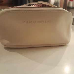 Beige necessär från Rose of No Man's Land - Snygg och praktisk beige necessär från Rose of No Man's Land. Perfekt för att organisera dina skönhetsprodukter. Den har en dragkedja upptill för enkel åtkomst.
