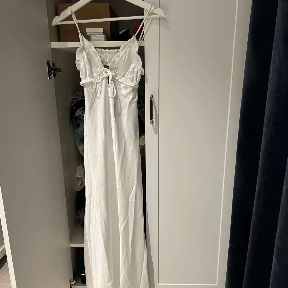Supersöt vit midiklänning från Zara i XS. Tunna justerbara axelband och knytning framtill🎀 Klänningen har volangdetaljer vid bysten och öppen rygg med resårdetalj! Dragkedjan på sidan  är smidig och diskret🤍Endast testad och lappen kvar, säljes då den ej kommer till användning🌸. Mekot.