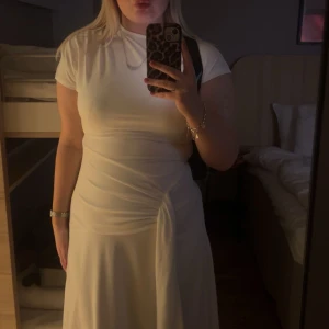 Vit klänning med knyt - Jättefin midiklänning! Mjuk och skön i materialet. Slutar strax över mina anklar. Jag är 168cm lång. Endast använd en gång. 