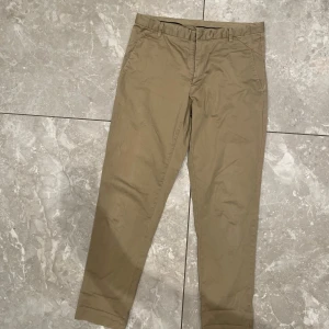 Beige chinos - Snygga beige chinos med normal passform. Perfekta för en stilren look. De har en klassisk design med knappar och dragkedja framtill.