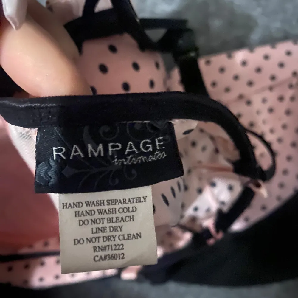 den är storlek xs-s !Säljer en söt rosa korsett från Rampage med svarta prickar och detaljer. Den har justerbara axelband och en liten rosett framtill. Perfekt för en speciell kväll!. Yläosat.