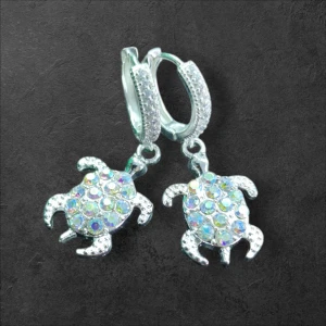 Glittriga sköldpaddsörhängen - Snygga örhängen med sköldpaddsdesign, dekorerade med glittrande stenar i regnbågens färger. Perfekta för att ge en unik touch till din stil. Örhängena har en silverfärgad bas och är lätta att bära.