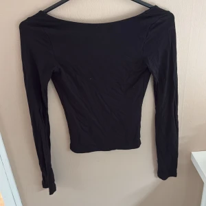 Svart långärmad topp - Snygg svart långärmad topp med öppen rygg från Gina i storlek xxs, använd ett fåtal gånger innan men inga defekter eller liknande 