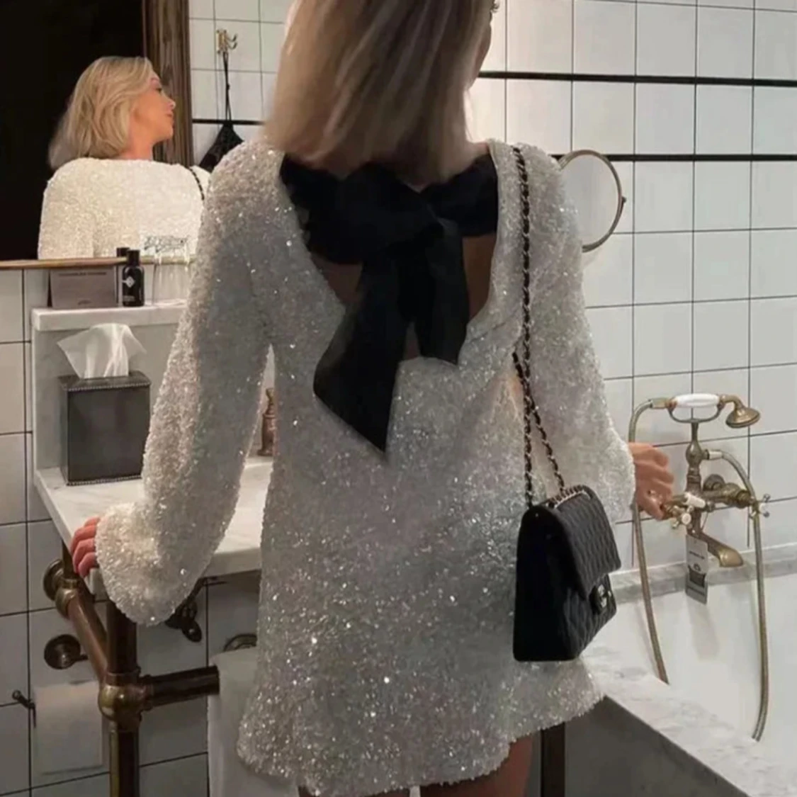 Vit glittrig klänning med svart rosett