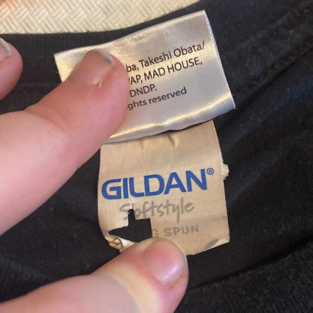 Säljer en svart t-shirt med Death Note-tryck från Gildan. T-shirten har ett stort vitt tryck av en karaktär på framsidan och är kortärmad. Perfekt för fans av serien!. T-paidat.