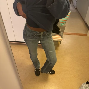 Blå jeans från Levi's - Säljer ett par klassiska blå jeans från Levi's med en straight passform. De har en låg midja och är perfekta för en avslappnad stil. Jeansens design inkluderar de ikoniska bakfickorna med Levi's logotyp.