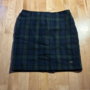 Rutig kjol från Hampton Republic.  - Snygg rutig kjol från Hampton Republic i mörkblått och grönt med inslag av rött. Kjolen har en klassisk design och är perfekt för en stilren look. Märkesdetalj på framsidan ger en extra touch. PRIS kan diskuteras!